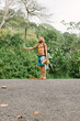 © denni/Stocksy - Man with no shirt on hitchhiking on the side of the road.