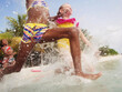 © absphotography/Stocksy - Girls running , jumping and splashing into the water at the beach