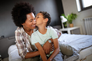 Wall Mural - Happy mother playing, having fun, hugging with her son at home