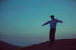 © HOWL/Stocksy - young man on windy mountaintop