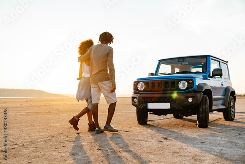 Fotografía Image of african american couple walking while travelling with car