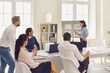 © Studio Romantic - Young woman demonstrates some new project ideas to her partners in a conference room.