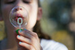 © Jacqui Miller/Stocksy - Closeup of girl blowing a bubble