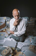 © stokkete - Pensive businessman surrounded by paperwork