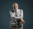© stokkete - Pensive businessman leaning on a pile of paperwork