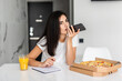 © F8  \ Suport Ukraine - Portrait of young woman eating pizza and use phone while working from home