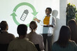 © Seventyfour - Portrait of young African-American woman giving speech on renewable energy during recycling and waste management conference, copy space