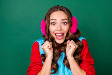 Sticker - Photo of pretty lovely young lady open mouth excited look raise fists horse arrives first win first place cup wear pink ear warmers blue vest red sweatshirt isolated green color background