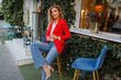 © Svetlana Sokolova - Beautiful woman in  red jacket resting in street cafe. Charming  long -haired lady in  suit sensitively looks into camera and chilling outside.