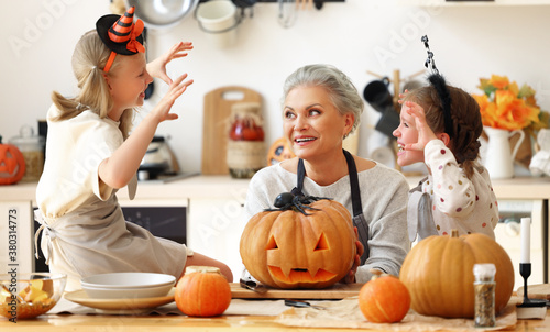 Cuadros en Lienzo Granddaughters scaring grandmother during Halloween celebration.