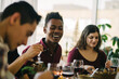 © CWP, LLC/Stocksy - Friends laughing and having a good time around the table while enjoying Thanksgiving dinner
