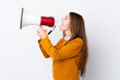 © luismolinero - Young woman over isolated white background shouting through a megaphone