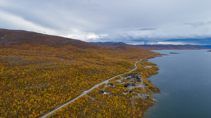 Wall Mural - Top view of the lake shore with autumn forest and road. Village northern landscape. Lapland, Kilpisjarvi.