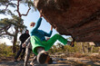 © Tristan Kwant/Stocksy - Man climbing up a boulder route