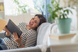 © Tetra Images - Portrait of happy woman lying on sofa with tablet pc