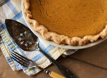 Pumpkin Pie On Cloth With Old Fashioned Cutlery On Wood