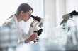 © Tetra Images - Female lab technician analyzing sample through microscope