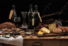 Still Life With Wine Bottles, Selection Of Cheese, Bread And Nuts On Wooden Table, Studio Shot