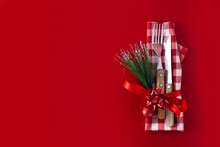Fork, Knife And Christmas Decoration On Red Background. Copy Space