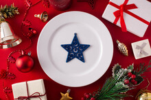 White Plate With Blue Star And Christmas Ornament On Red Background