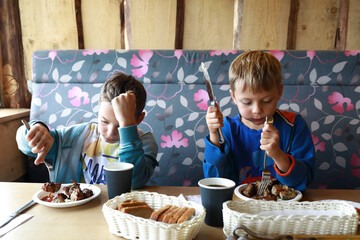 Boys eating pork kebab