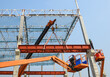 © Sumith Nunkham - Construction workers installation steel structure girder runway beam lifting by mobile crane and placing on corbel of column concrete at the construction site project