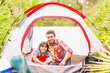 © Daniel Grill/Tetra Images - Father and son (12-13) sitting in tent