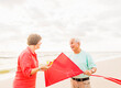 © Tetra Images - Couple flying kite together on beach