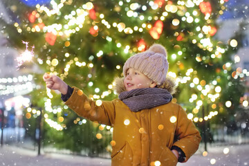 Wall Mural - Little boy having fun with his family on traditional Christmas fair. Winter holiday traditions.