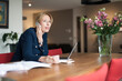 © Mark de Leeuw/Tetra Images - Woman talking on phone and making notes
