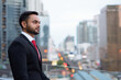 © Ranta Images - Young bearded Indian businessman against view of the city