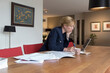 © Tetra Images - Businesswoman working art home