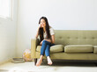 © Jessica Peterson/Tetra Images - Portrait of happy young woman sitting on sofa