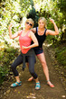 © Tetra Images - Two woman flexing muscles in forest