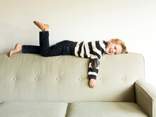 Boy (6-7) Lying On Sofa