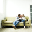 © Jessica Peterson/Tetra Images - Family embracing on sofa