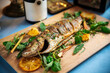 Roasted sea bass with herbs on the wooden board