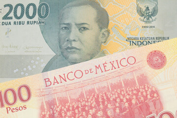 A macro image of a grey two thousand Indonesian rupiah bank note paired up with a red and yellow one hundred peso bill from Mexico.  Shot close up in macro.