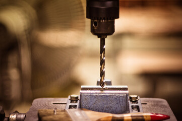 Electric drill with drill chuck and stand for mechanics. Selective focus