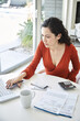 © Trinette Reed/Stocksy - Hispanic woman paying bills on the computer at home