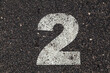 © MyMicrostock/Stocksy - Number 2 Printed on White Over Dirty Asphalt