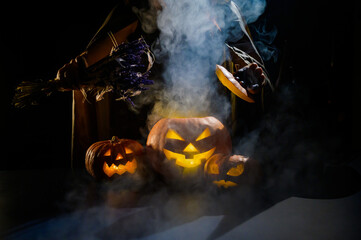 Witch casts a spell on a steaming pumpkin in the dark on Halloween