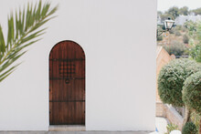 Arched Wooden Door And Exterior Of White Building