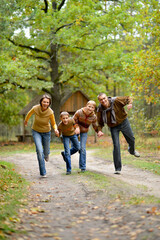 Poster - Family of four having fun in autumn forest