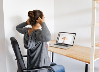 Woman doing stretching yoga at her office by online sport video. Fitness at work. 