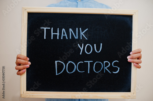 Thank you, doctors. Coronavirus concept. Boy hold inscription on the board.