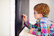 © Angela Lumsden/Stocksy - Child drawing on a chalkboard