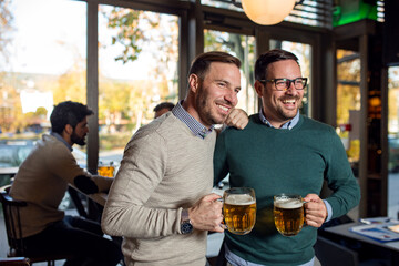 Wall Mural - Friends in pub drinking beer and talking