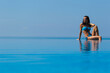 © Felix Hug/Stocksy - A young woman sitting on a pools edge