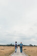 © Cindy Prins/Stocksy - Two men hiking with backpacks on a long road in the fields